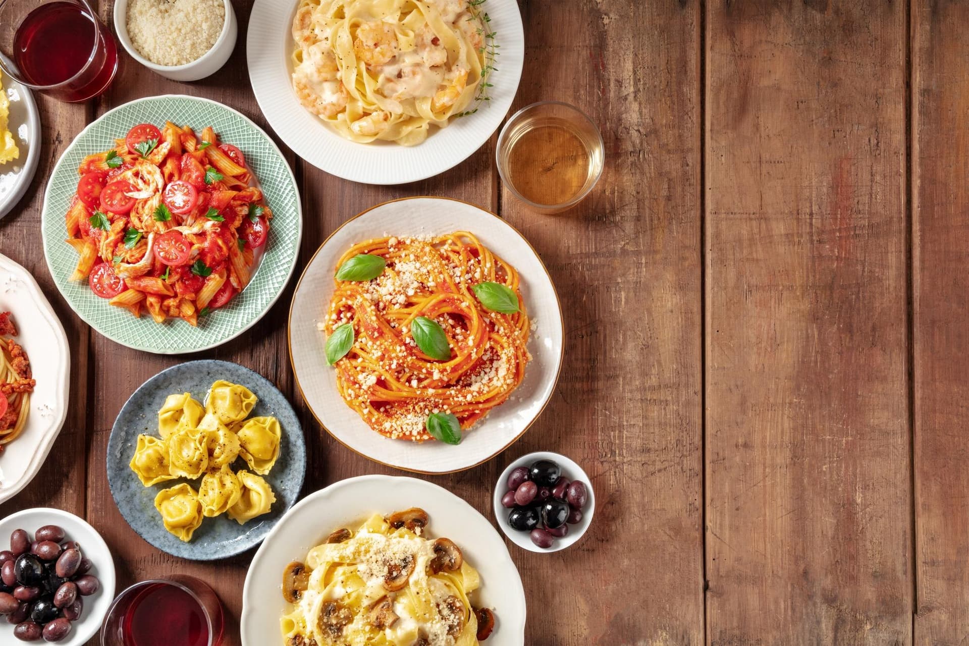 Overhead flat-lay of pasta dishes — the kind of dish-level content a real menu page can rank for
